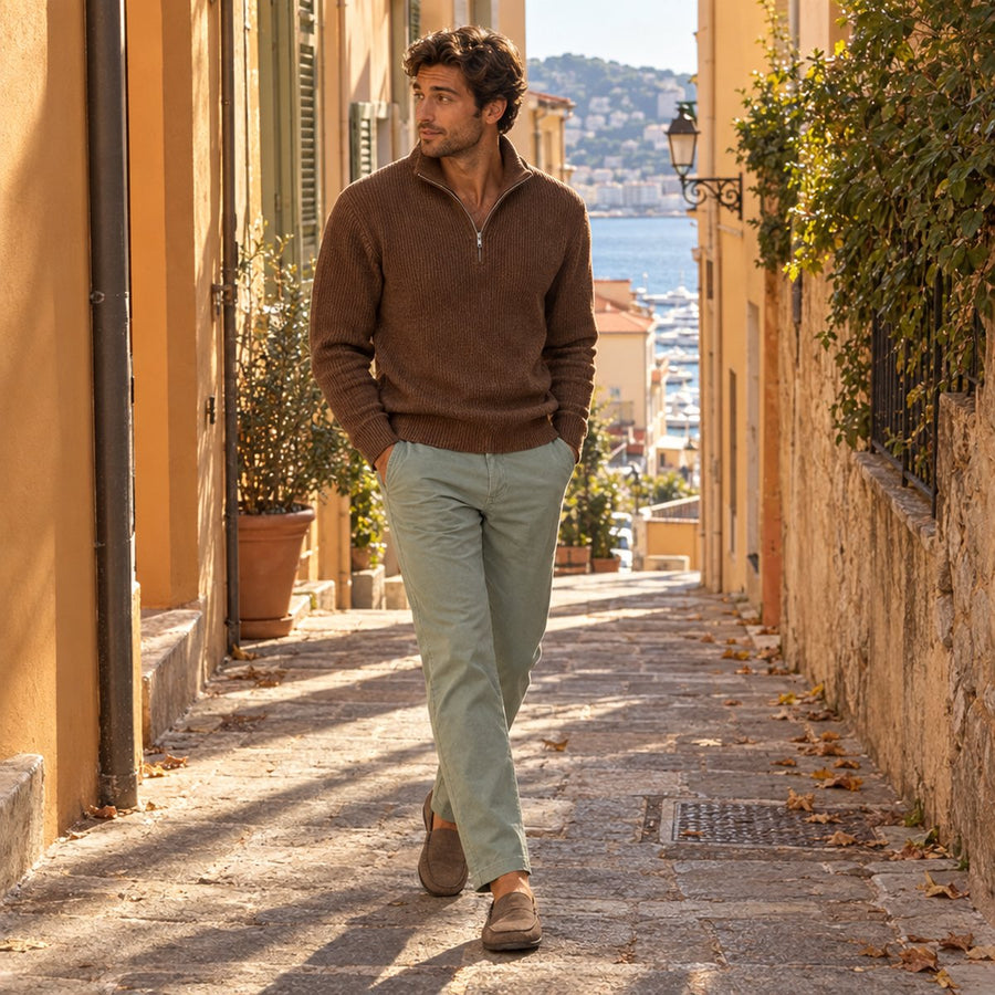 Saint Véloir patron in the Menton quarter-zip walking through a sunlit Monaco alley