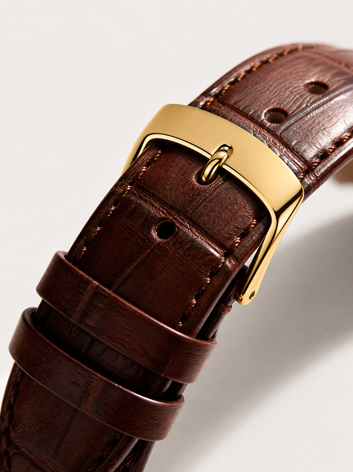 The Saint Veloir Timepiece — gold pin buckle and cognac leather strap detail