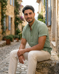 The Antibes Shirt - Sage on model, seated in Provencal alley